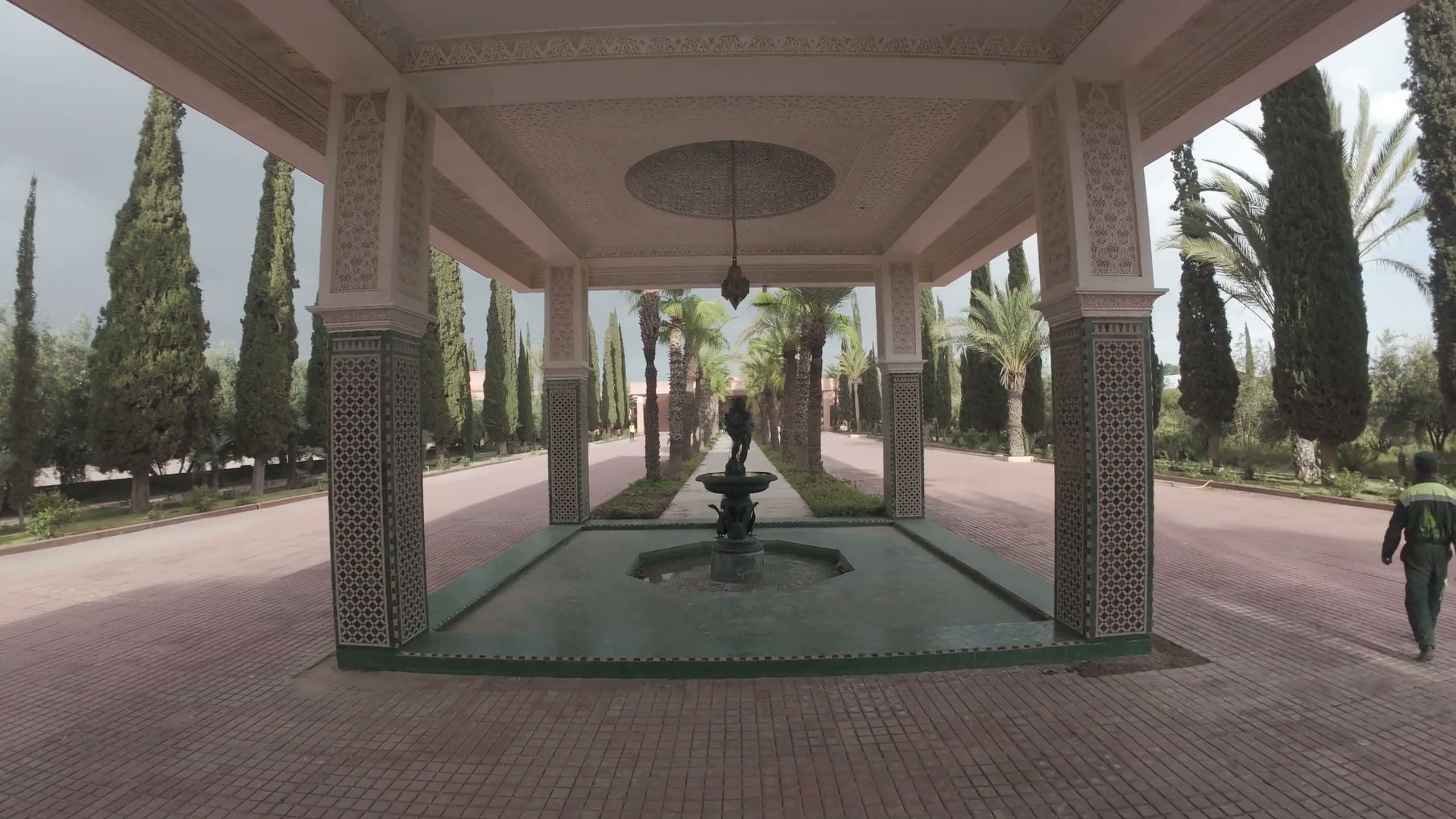 Patio de riad marocain vu à travers une porte sculptée